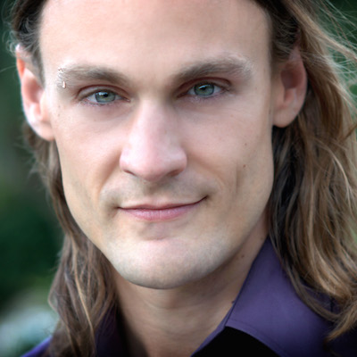 Portrait of Zachary Crockett, long light brown hair, clean shaven, purple shirt collar